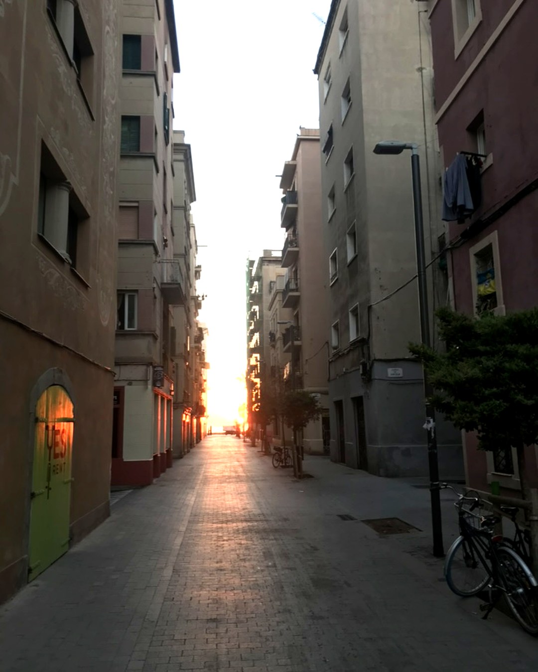Strada del quartiere della Barceloneta al tramonto con il mare sullo sfondo