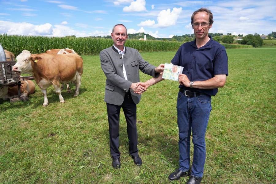 Ortstermin mit Medienrummel: Bayerns Wirtschaftsminister Hubert Aiwanger von den Freien Wählern (links) sorgt sich nach dem Kuhfladen-Bußgeld um den Bauernstand. Hier mit Landwirt Georg Schweiger bei der Übergabe des Bußgeldes. (Foto: StMWi Bayern)