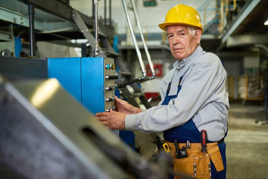 Älterer Arbeiter bedient eine Maschine. (Symbolbild: iStock/SeventyFour)