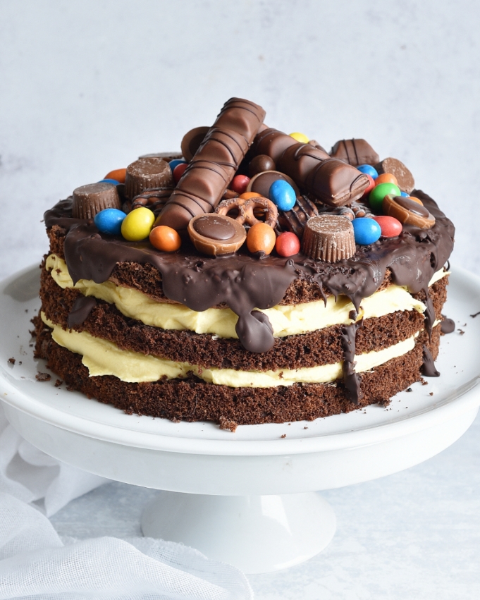 Süßigkeiten Torte mit Vanille-Sahne-Creme in der Mitte und Süßigkeiten oben drauf, einfach zu machen