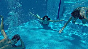 Personas buceando dentro de la piscina