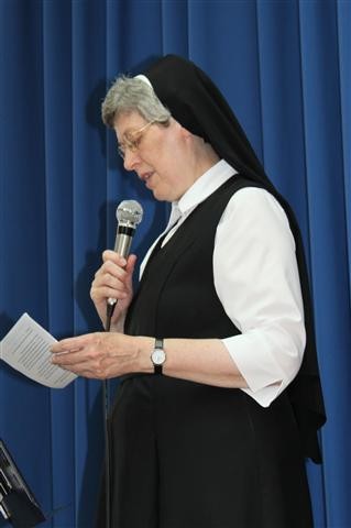 Sr. Rita begrüßt die komplett versammelte Schulgemeinschaft in der Turnhalle.