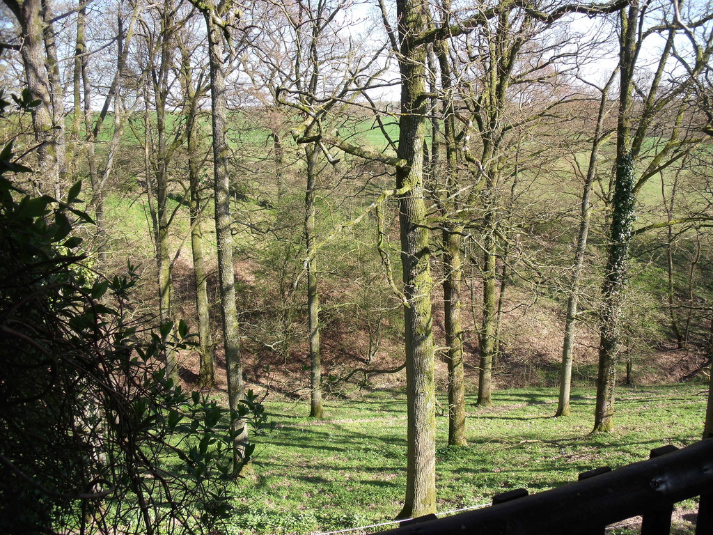 Une terrasse et des pelouses surplombant la vallée avec des meubles de jardin et un barbecue