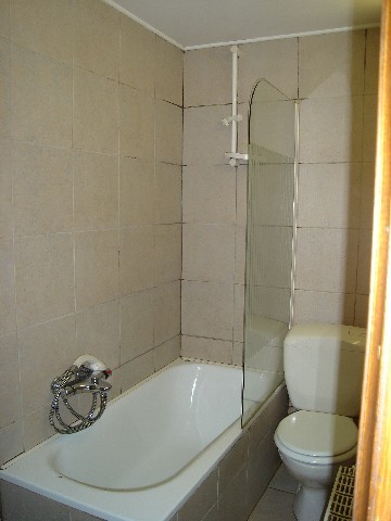 A bathroom with bath - shower, washbasin, WC