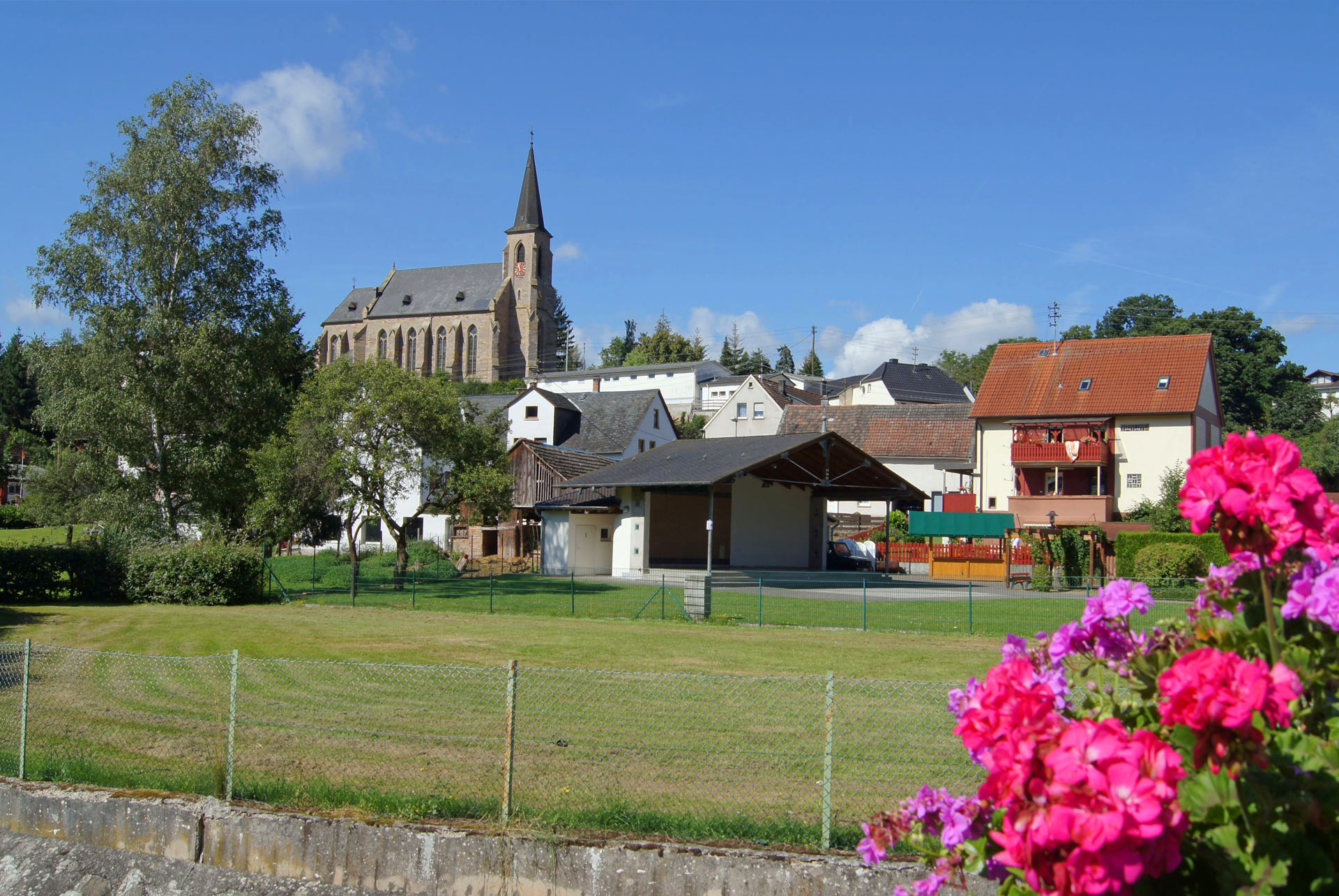 Blick von der Brücke auf Dorfplatz und Kirche