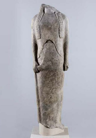 Een vrouwenfiguur, waarschijnlijk Ornithe voorstellend, staat in een frontale houding, met beide benen bij elkaar en haar armen langs haar lichaam. Ze draagt ​​een chiton met middellange mouwen en een riem, met een lange overvouw. Museum Berlijn.