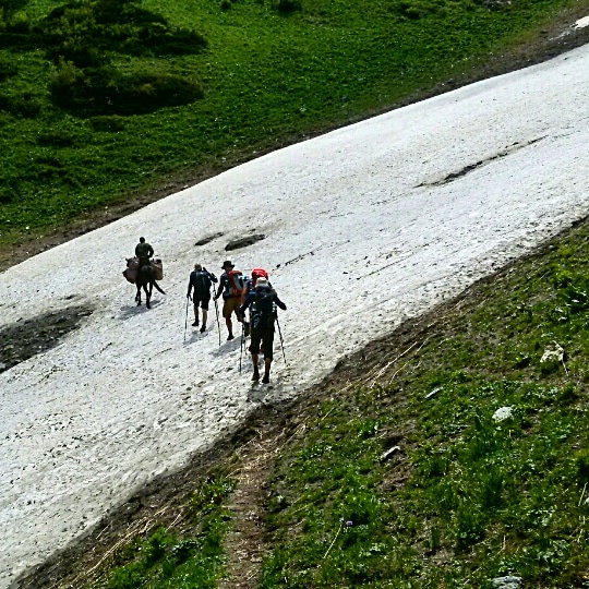 Crossing the snow path on the Trekking route in July 