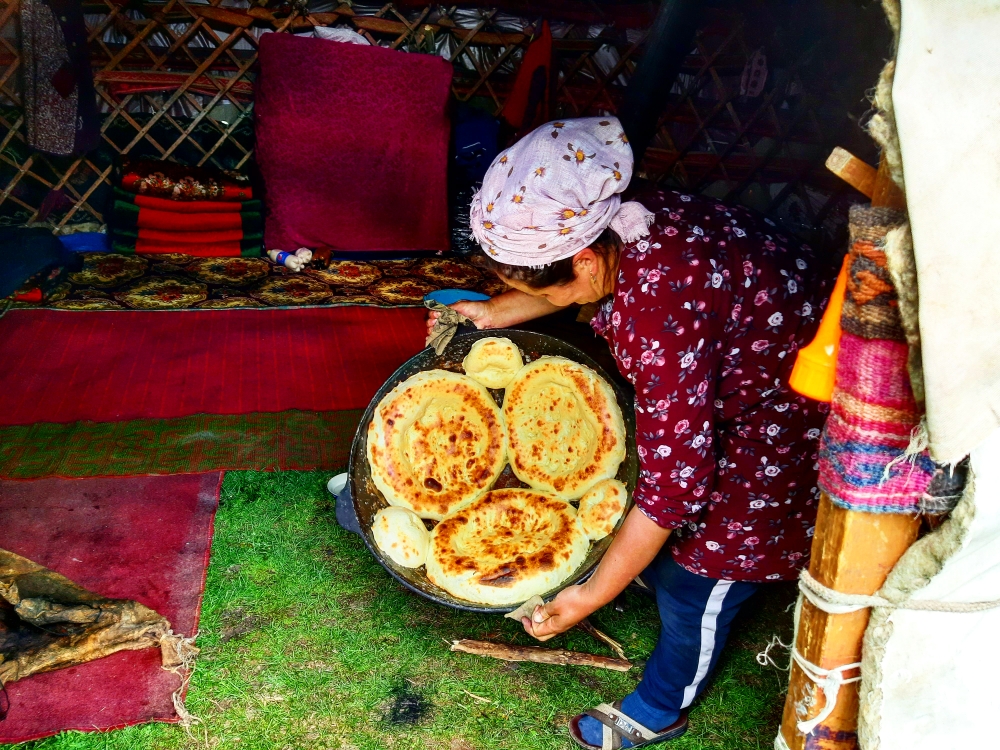 Kyrgyz Nomad woman baking a Nan(bread)in the big pot,inside of the Boz-yui (yurt)