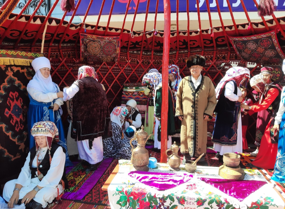 Kyrgyz Nomads in traditional clothes inside of Bozyui ( Yurt)