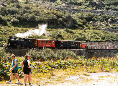 Dampfbahn Furka Bergstrecke stoomlocomotief met rijtuigen staat klaar voor vertrek in Gletsch.