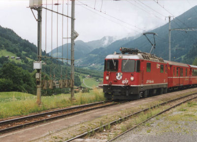 RhB loc 627 komt vanuit de regen op station Sumvitg toegereden. Ze is net vertrokken uit Disentis en op weg naar Chur. 