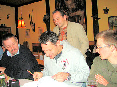 Roman beim Signieren von DORGON, rundherum Andreas L., Karl Heinz und Niki