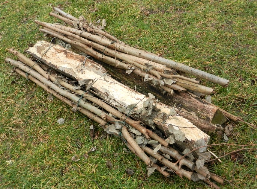 Buschvasen - eine Alternative zur Holzgestellkonstruktion. Zwei mit Drähten verbundene Zweigbündel werden über den Dachfirst gelegt