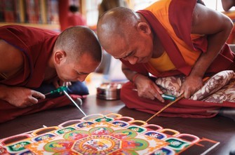 Tibetische Mönche erstellen ein Sand-Mandala