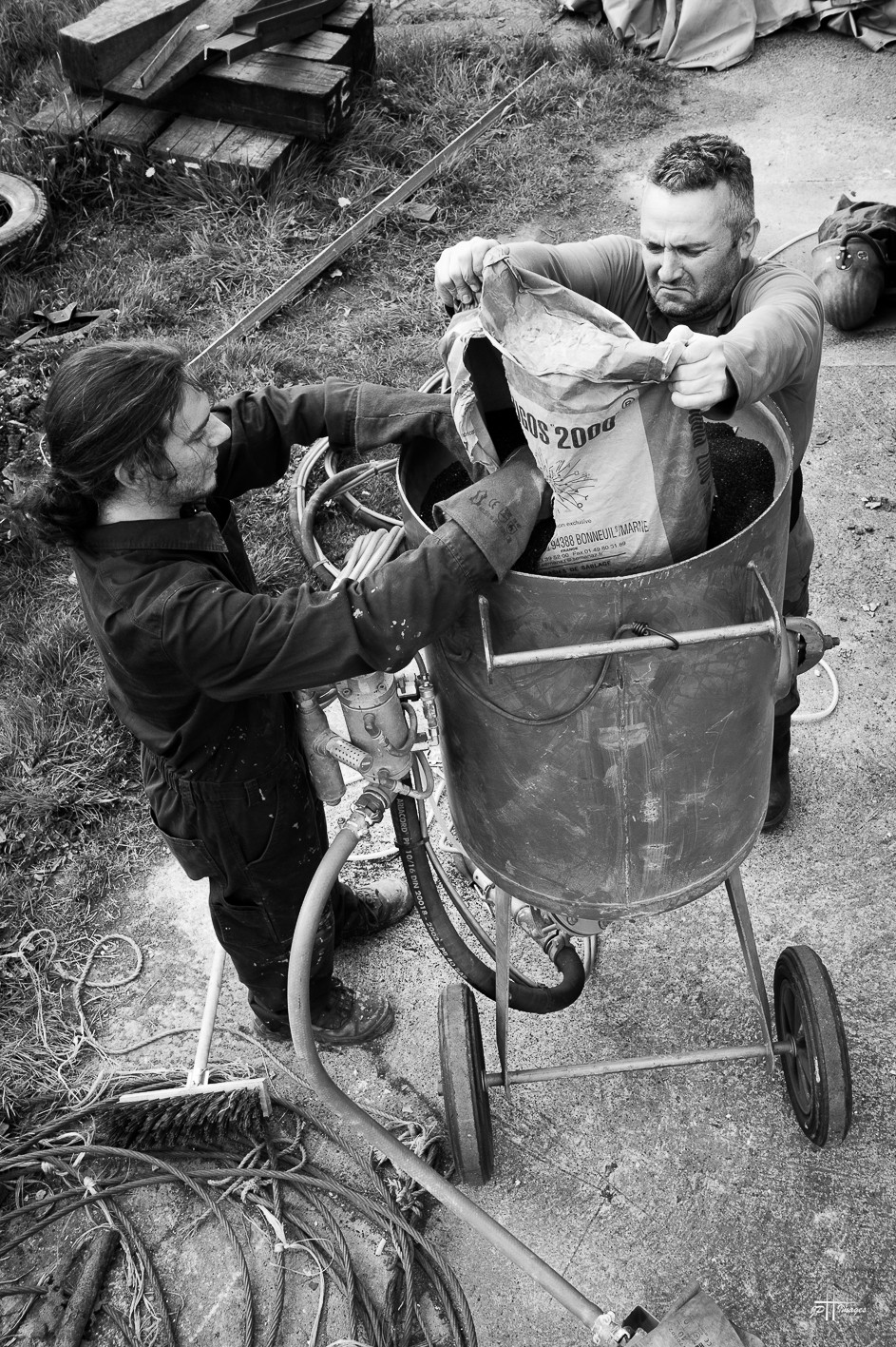 Julien et Philippe remplissant la cuve de la sableuse