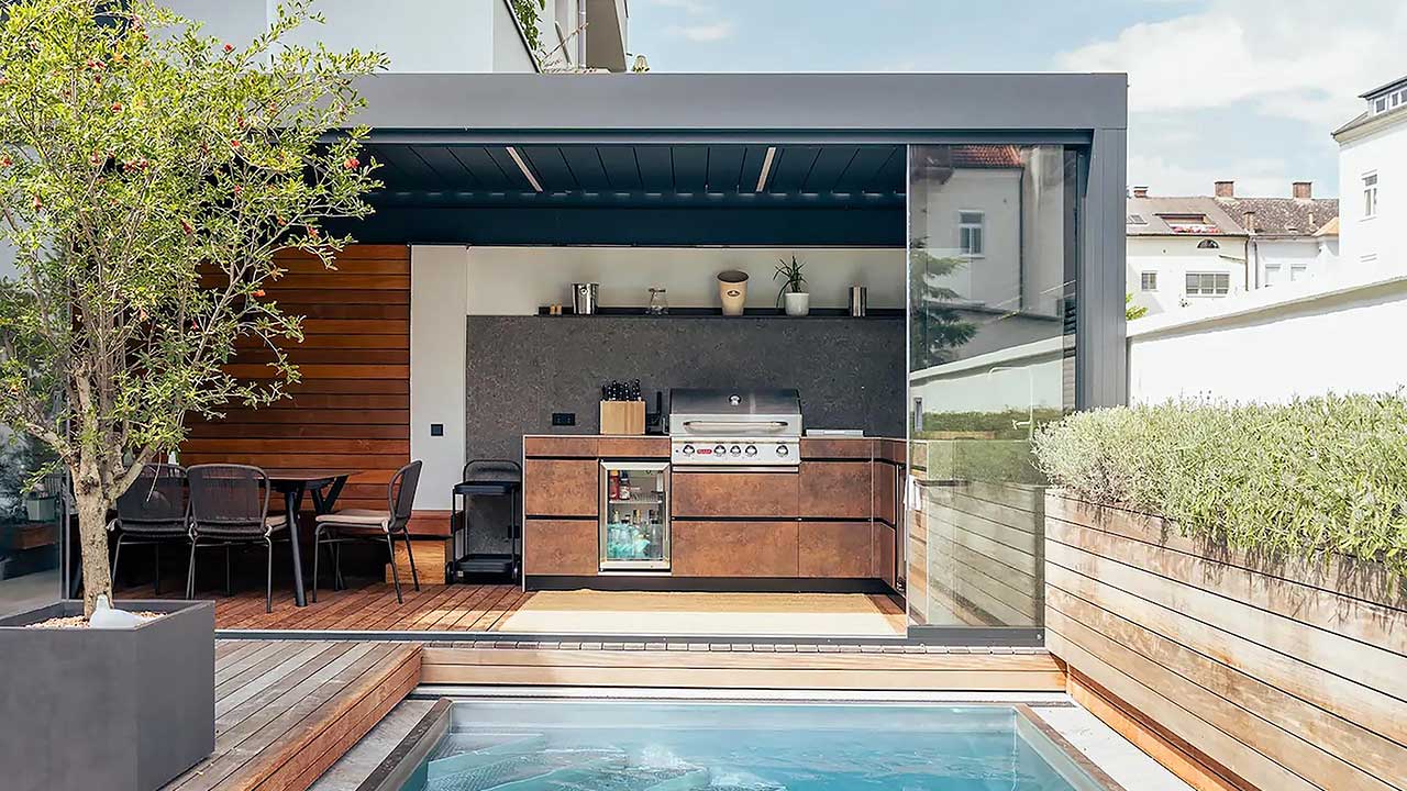 Robuste und multifunktionale Gartenküche in einer Pergola mit Lamellendach