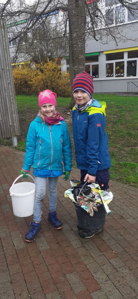 2 Kinder mit ihren vollen Mülleimern