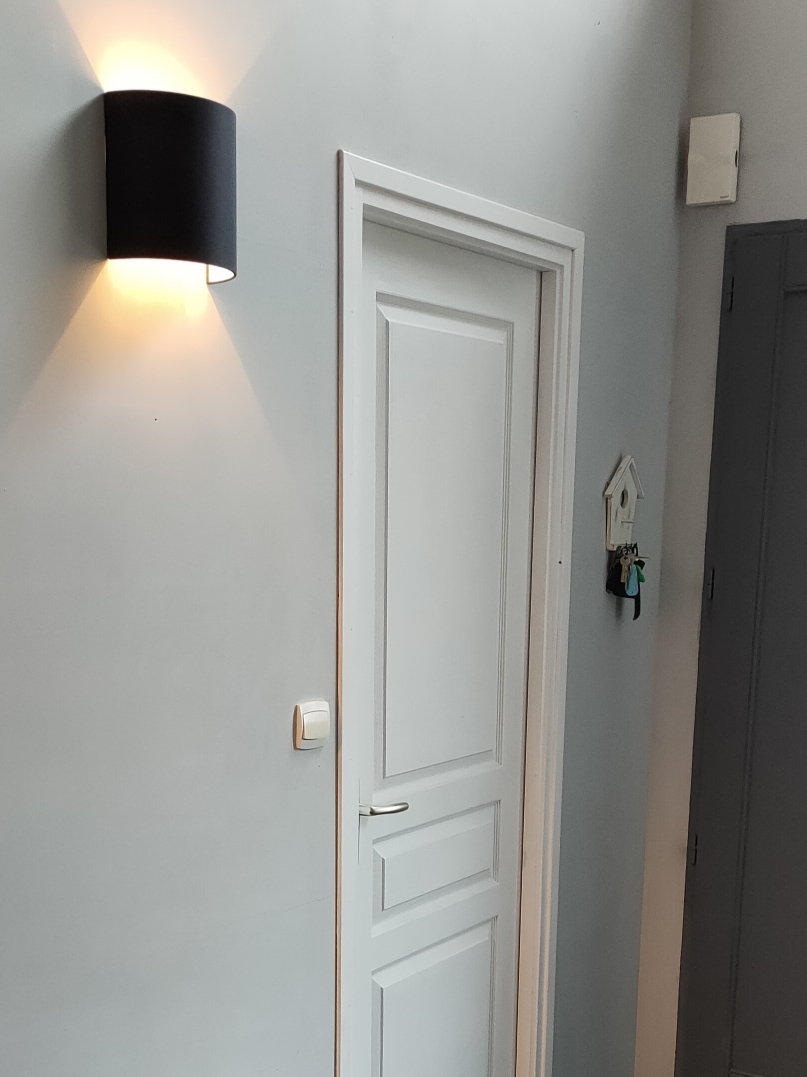 Applique murale unie S noire dans une entrée