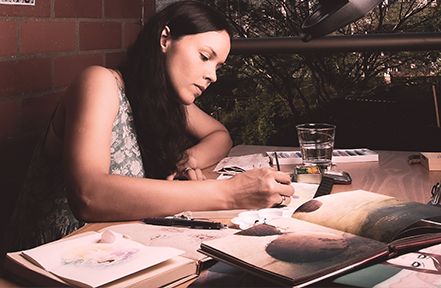 Josy Arteaga drawing (woman drawing on a table)