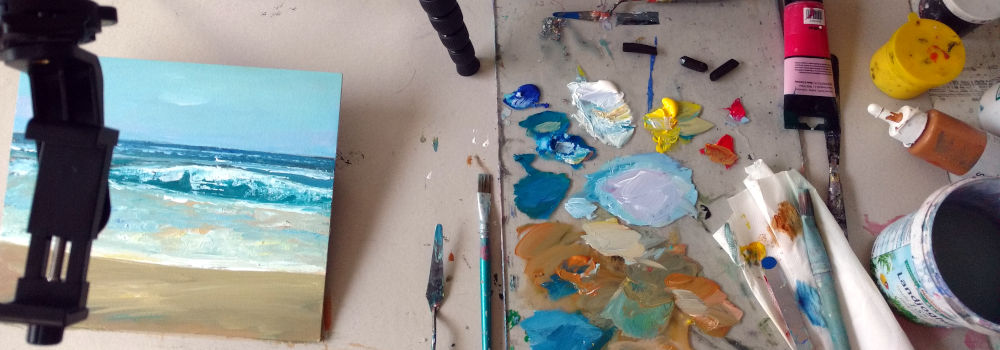 Arbeitstisch mit Farbtube, Palette und einem Bild