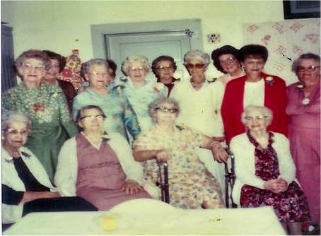 Foothills Events: The Blue Ribbon Circle pictured in the community center with the old quilt (right-hand corner), 1980 1st row: Emily Anderson, Liddia Maiers, Lula Domke, Violet Pipgras 2nd row: Hattie Cheek, Louise Bislerfeldt, Elsie Wruble, ? Olinger, ?