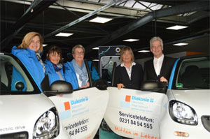 Anne Rabenschlag (Diakonie, 2.v.r.) übernimmt eine smart electric drive-Flotte von Gerd Hewing (smart Center Dortmund)