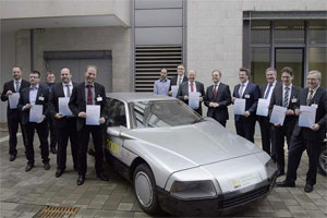 Die Repräsentanten der Projektpartner mit ihren Förderurkunden vor dem Projektfahrzeug des UNI-CAR-Projektes von 1982