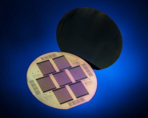 Monokristalline Siliziumsolarzelle mit POLO-Kontakten für beide Polaritäten auf der Solarzellenrückseite. Im Vordergrund ist die Rückseite von sieben Solarzellen auf einem Wafer zu sehen, im Hintergrund die gesamte Vorderseite.