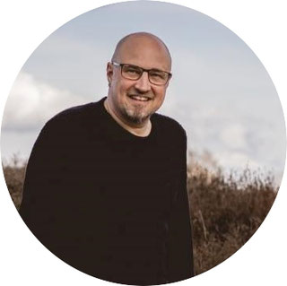 Portraitfoto von André in einem Heidefeld.