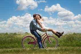 image showing what to look for in a relationship featuring a happy couple on a bike