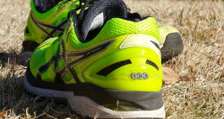 Training bei Hitze, Gelbe Turnschuhe auf vertrocknetem Rasen