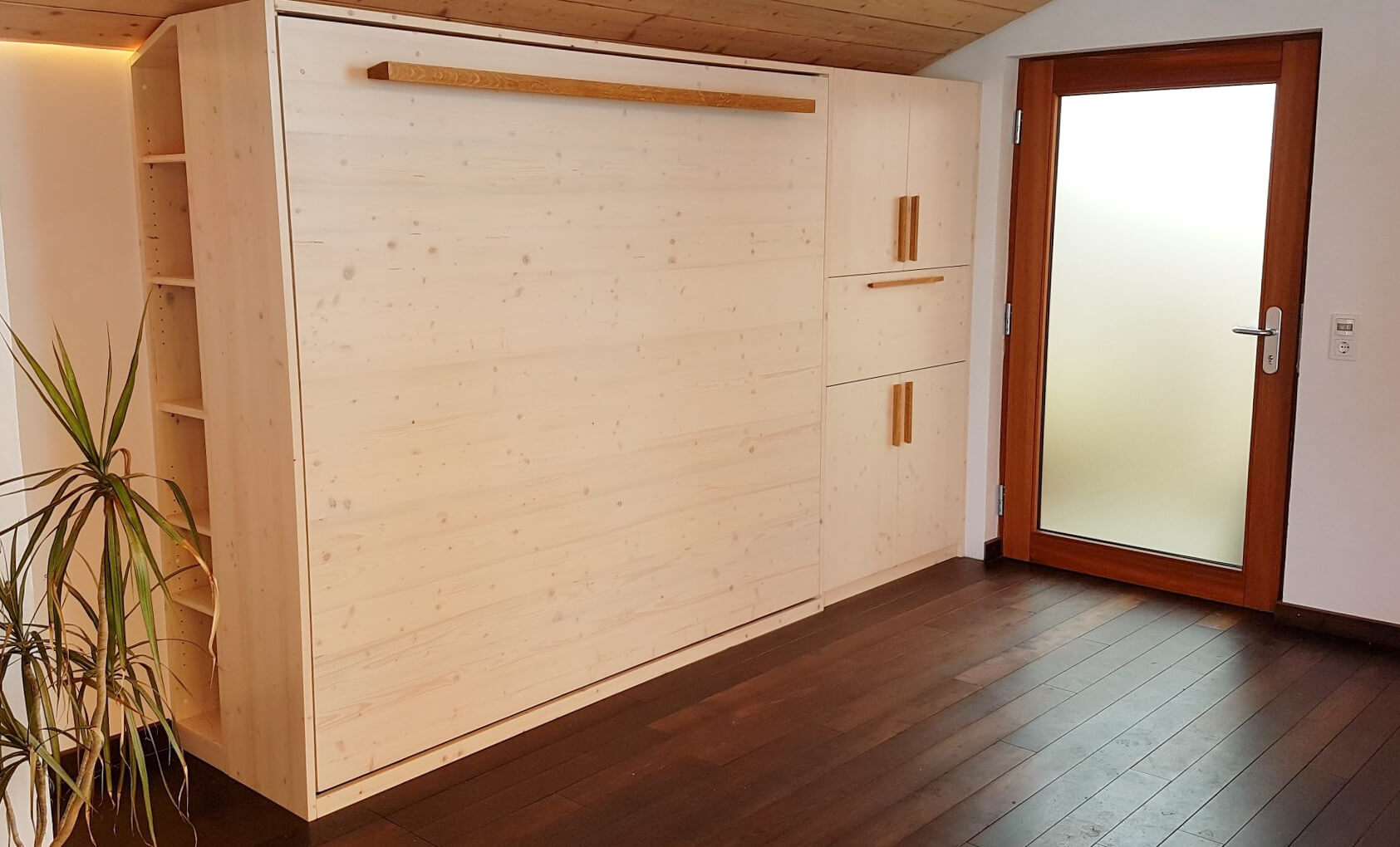 Klappbettschrank weiß lasiert mit Möbelgriffen aus Eiche. Dazu ein Barschrank mit Stauraum