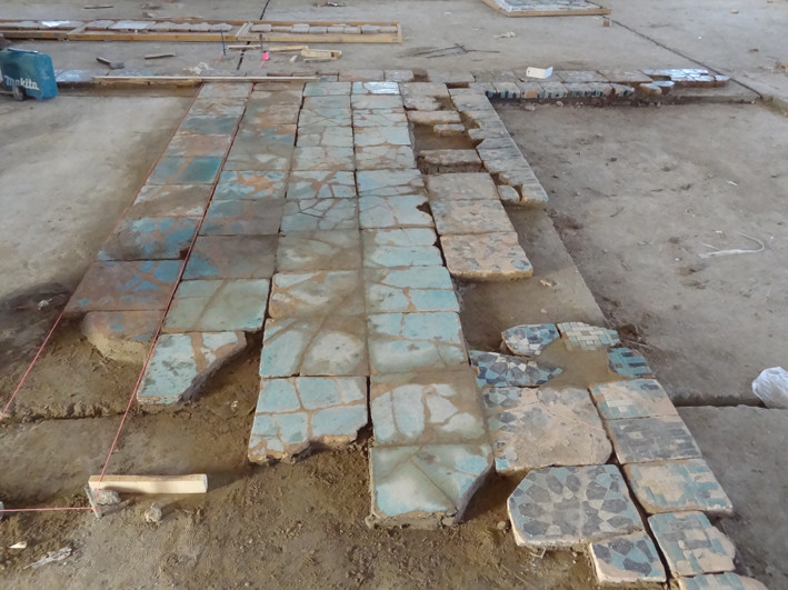 Les lignes sont maintenues droites et à la bonne hauteur par la pose de cardeaux, ici le fil rose. Les manques de carreaux ont été laissés tel quels  (Socra, 2013)