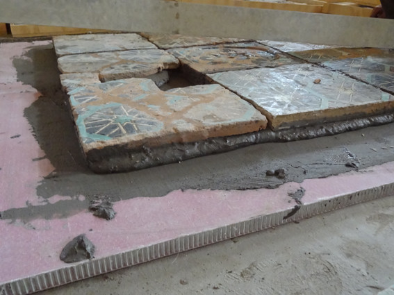 Vue sur la tranche du panneau nid d'abeille ("nids" gris en aluminium et surface en résine rose) et des carreaux (Socra, 2013)