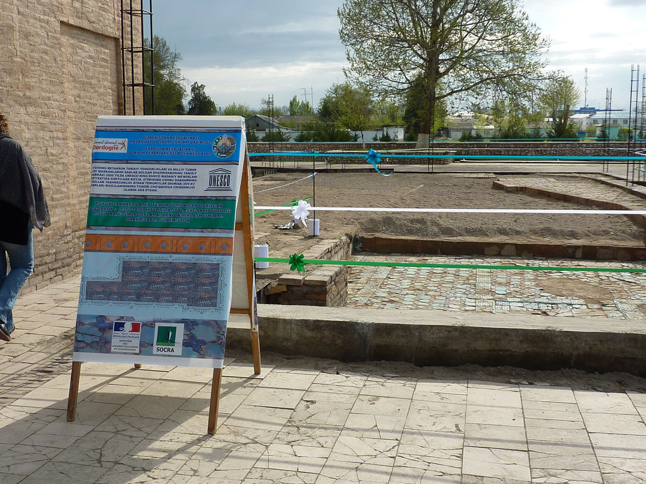 Panneau explicatif mis en place pour l'inauguration devant le pavement encore partiellement recouvert de sable (Socra, 2012)