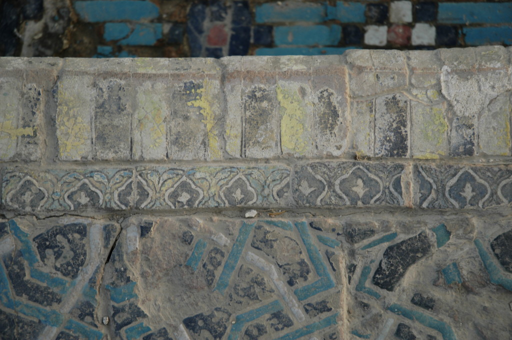 Carreaux de céramique glaçurée polychrome (bleu clair et foncé, blanc, noir, jaune, peut être rouge) formant les angles droits des bassins. (photo : C.Ollagnier, 2008)