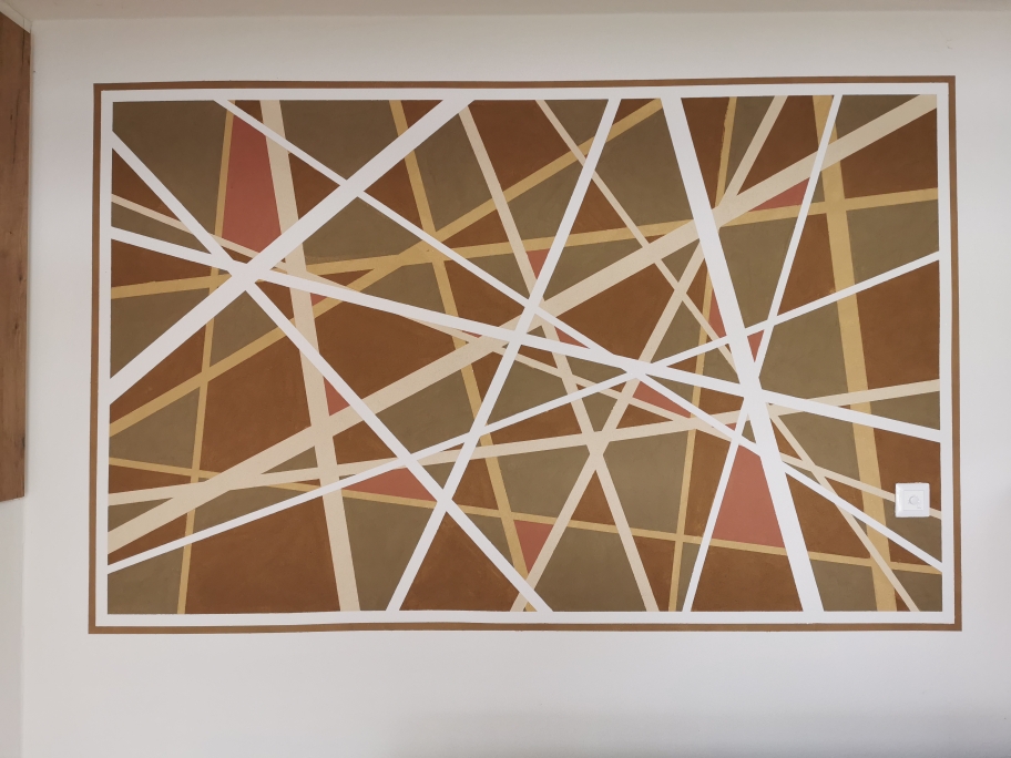 Geometrische Wandgestaltung mit Lehmfarbe in Cappuccino, Camel, Lehmbraun, Braun und Rot, überlagert von Linien in Marmorweiß, Weiß und Creme im Innenbereich.