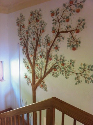 Lehmfarbe im Treppenhaus mit Apfelbaum-Motiv an der Wand