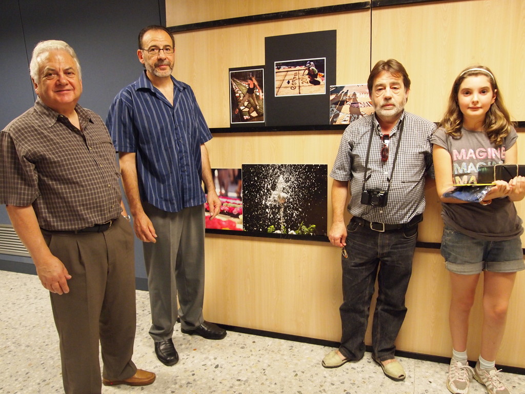 El jurat i la premiada infantil, amb les fotografies premiades