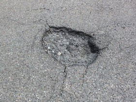 Loch im grauen Asphalt