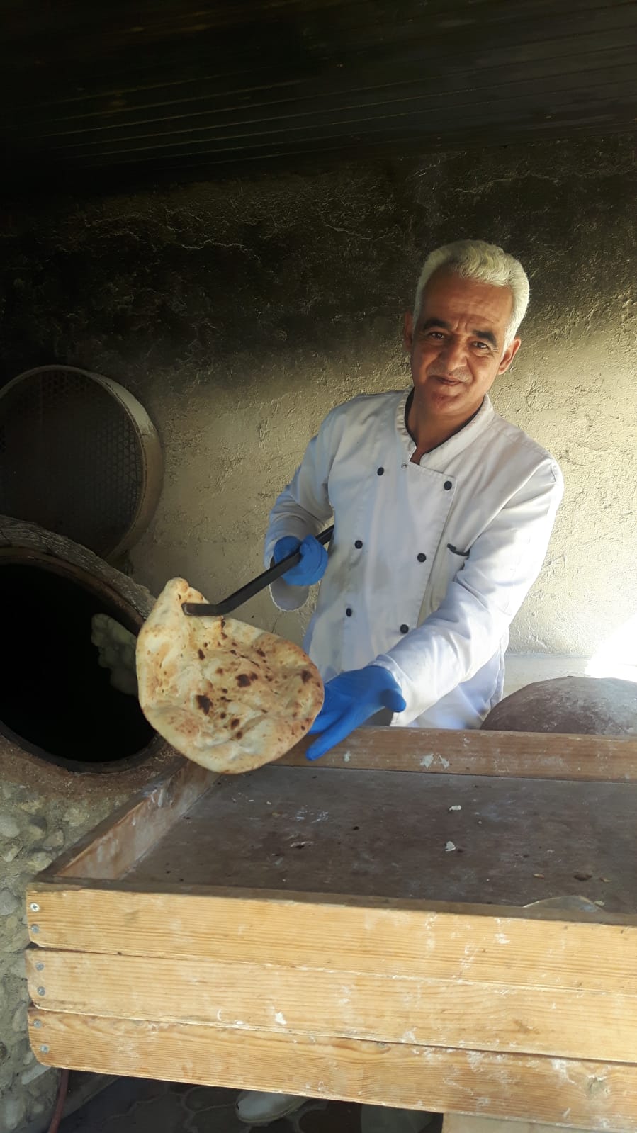Fladenbrotbäcker vor seinem Ofen