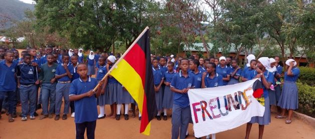 Schülerinnen und Schüler der Mwanga High School begrüßen Gäste aus Deutschland