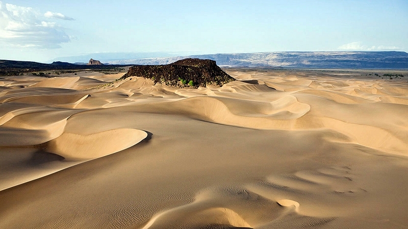 Kenya.  Suguta Valley. Dune con Aruba Rock visibile sullo sfondo. Qui le temperature raggiungono i 71°C