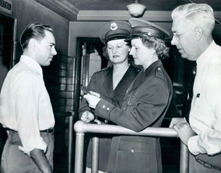 Detrioit, Michigan 1944 Ann Stankun and Louise Boer, the first women to serve as immigrant inspectors at the port of Detroit, are closely monitored by their supervisor during passport review.