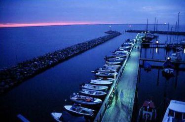 Der neue Hafen von Glowe, im Hintergrund Kap Arkona mit blinkendem Leuchtturm