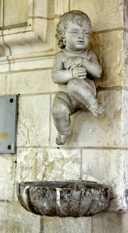 Bénitier insolite dans l'église de Cerisy- Que fait cet enfant au-dessus du bénitier?