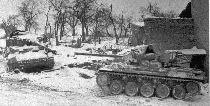 Ce M18 dépasse un Pz IV détruit durant la bataille des Ardennes, où ce sont illustrés les Hellcat