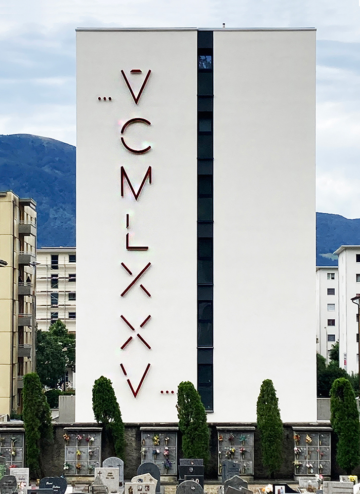 Frontal elevation of VCMLXXV by Paolo Grassi, featuring large red Roman numerals on a white building in Locarno.