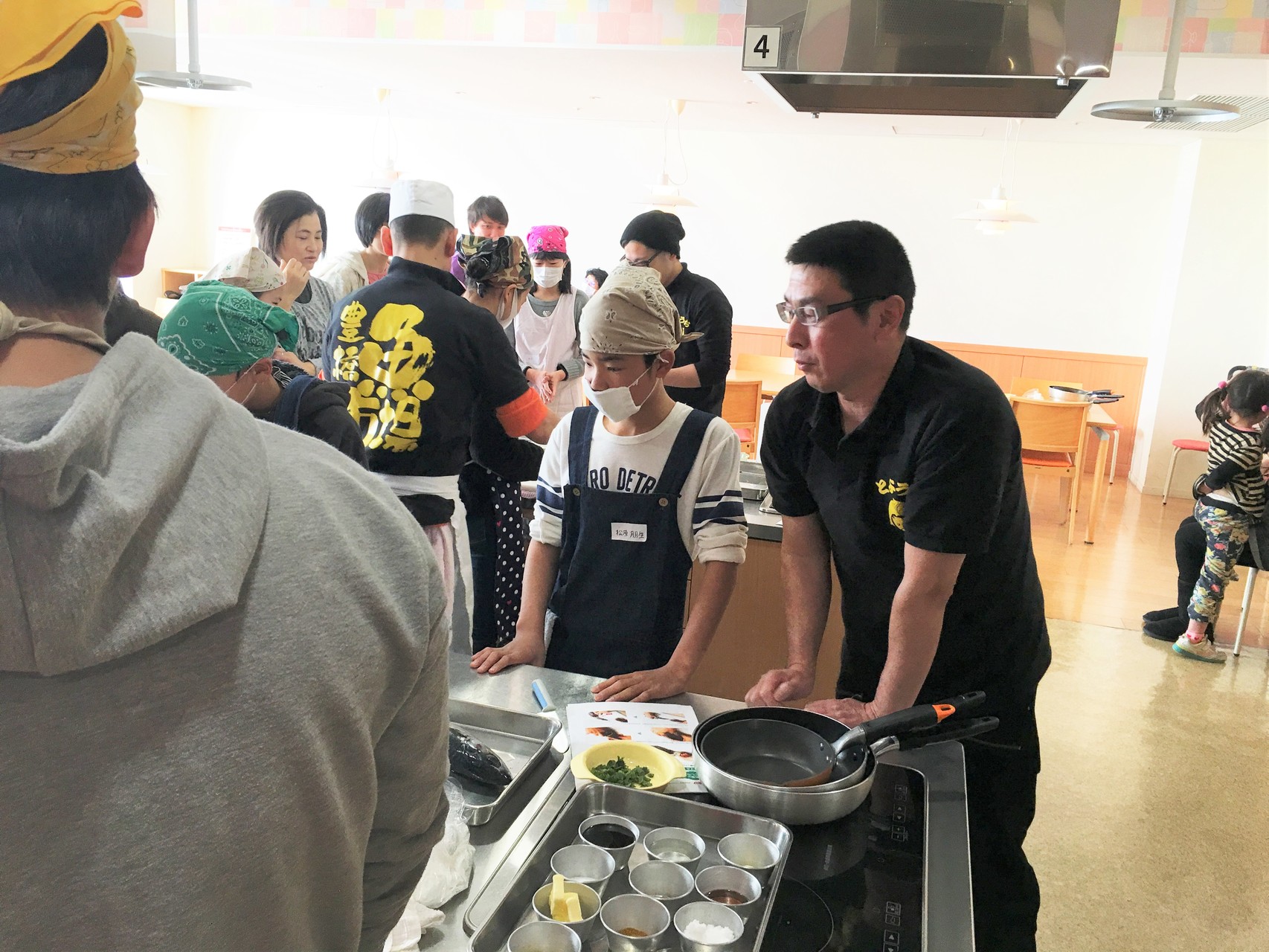 魚市場鮮魚部の富山さん（右端）の指導を受ける生徒。