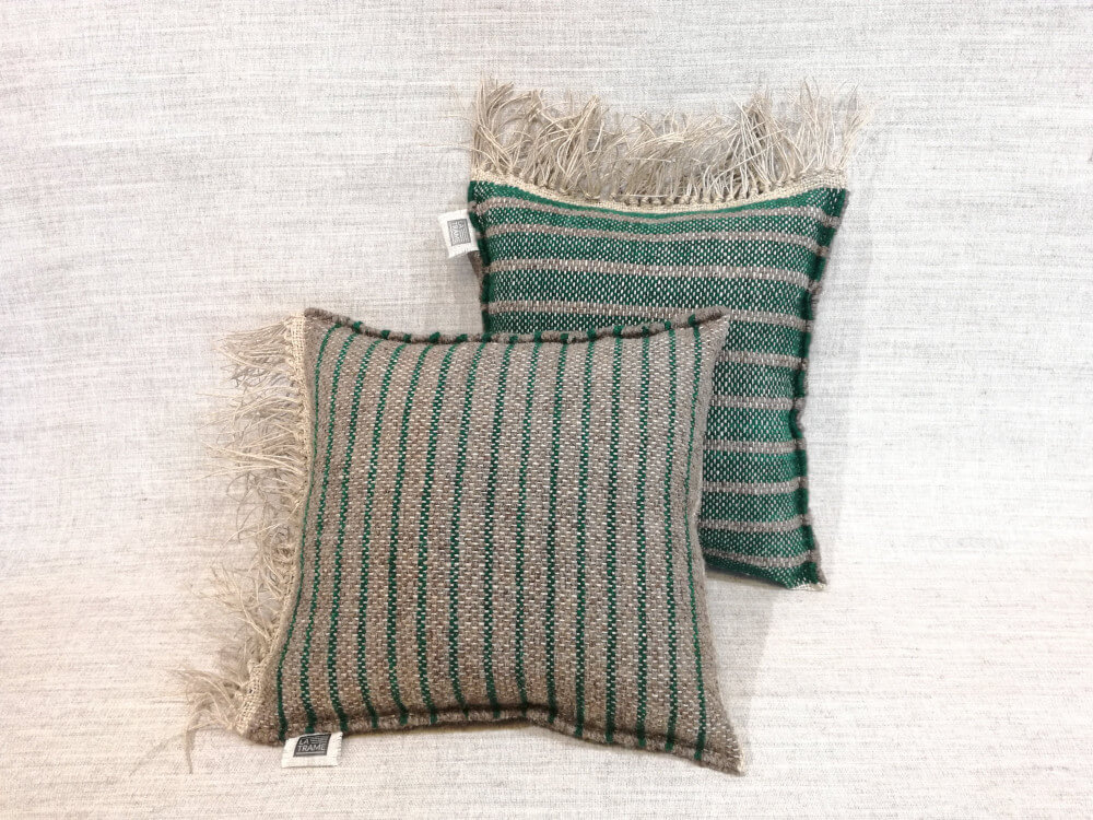 Deux coussins en laine pour chaise à rayures gris-vert et vert-gris, un derrière l'autre.